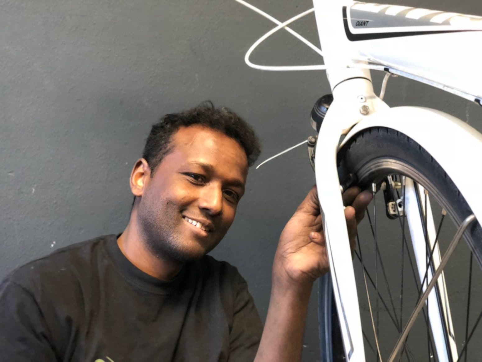 Mechaniker lächelt neben einem weißen Rad